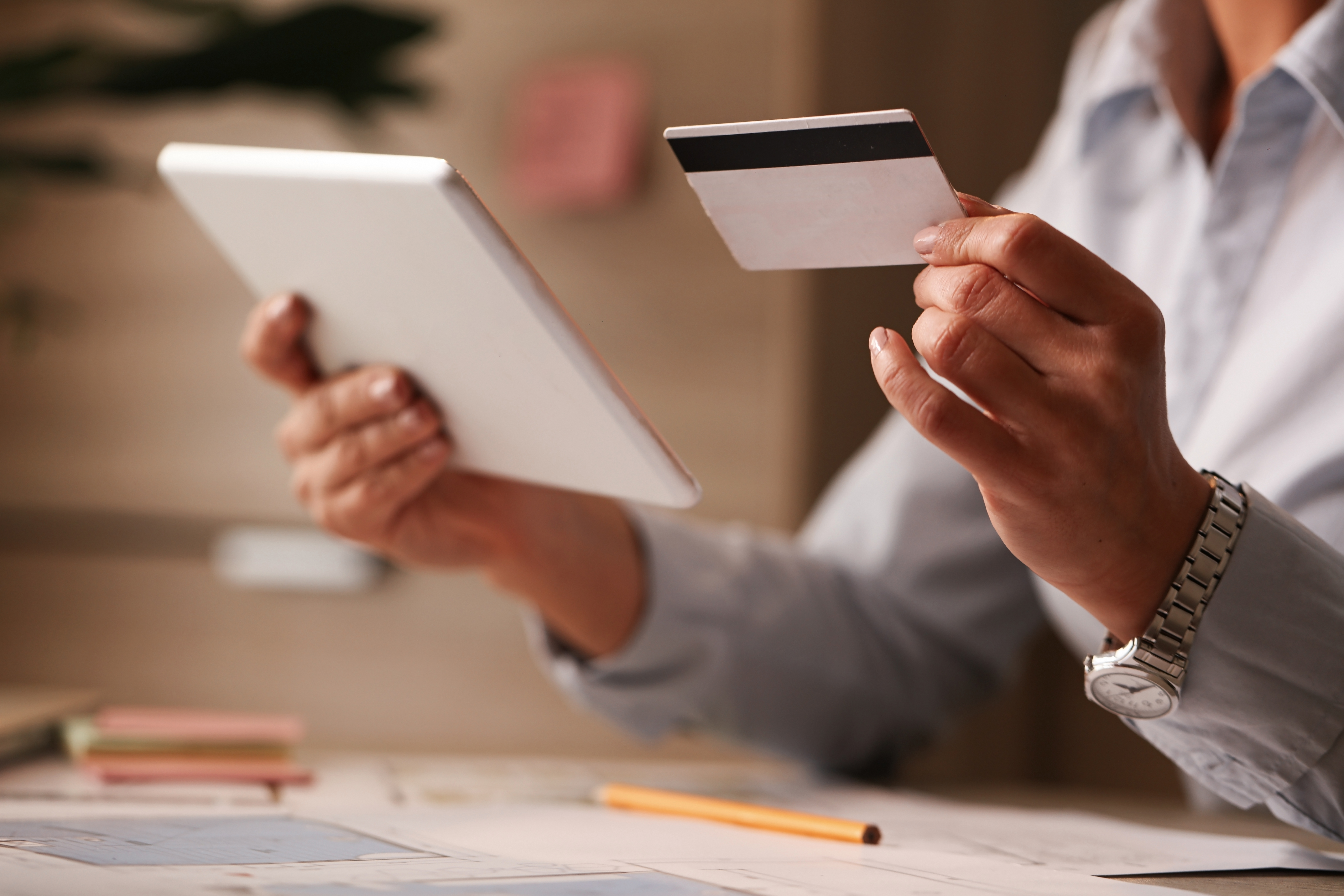 Business owner reviewing expense card spend controls at their desk, with per-card limits and category locks in view.