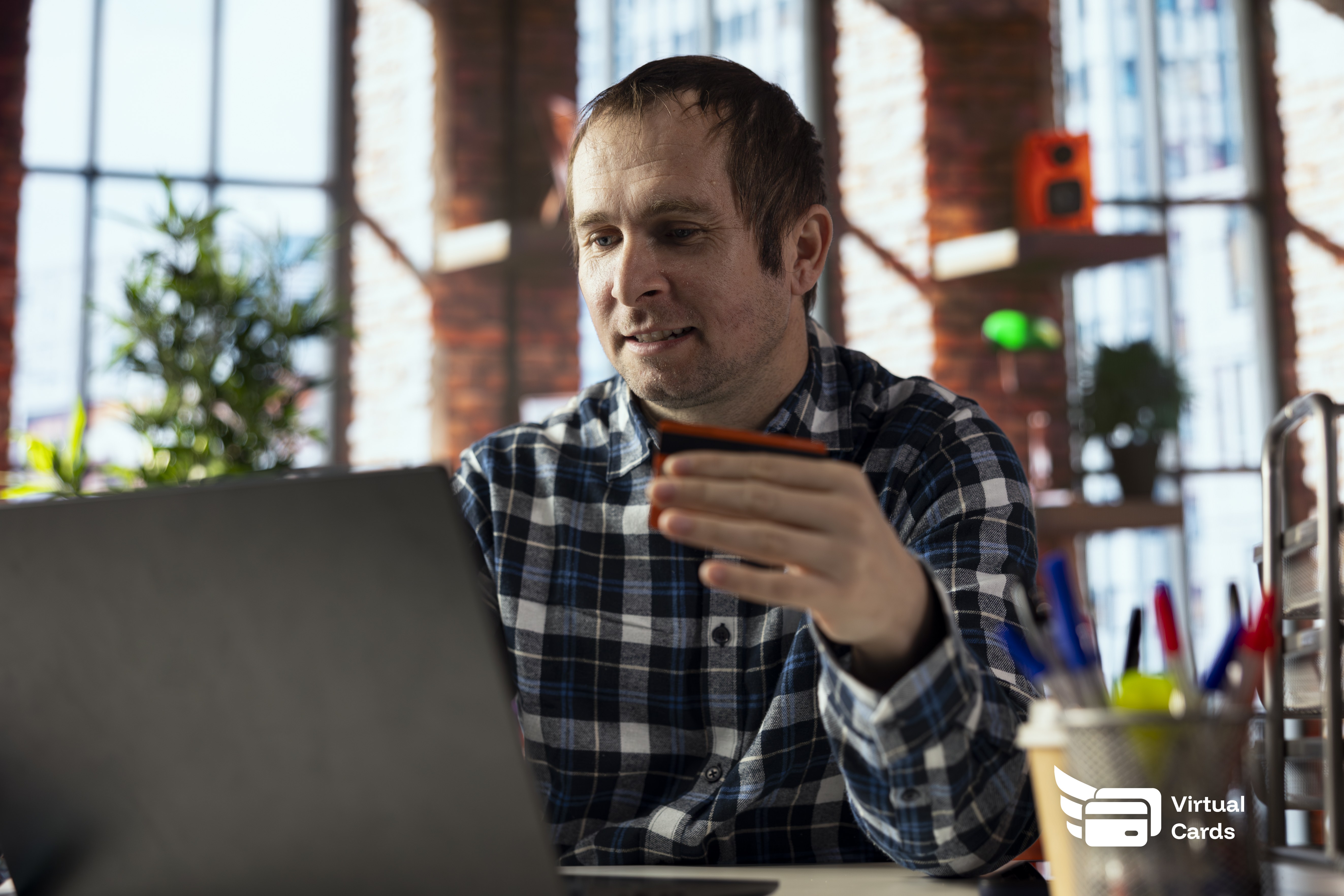 A professional at a desk entering a virtual card number to pay a freelancer online, keeping the main business card secure.