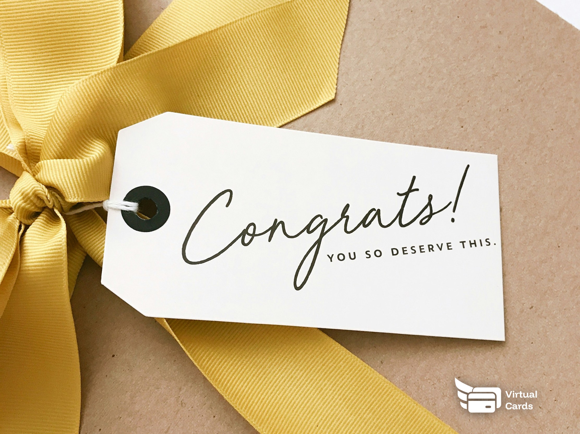 A wrapped gift box with a gold ribbon and a Congrats gift tag, representing virtual gift cards for employees.