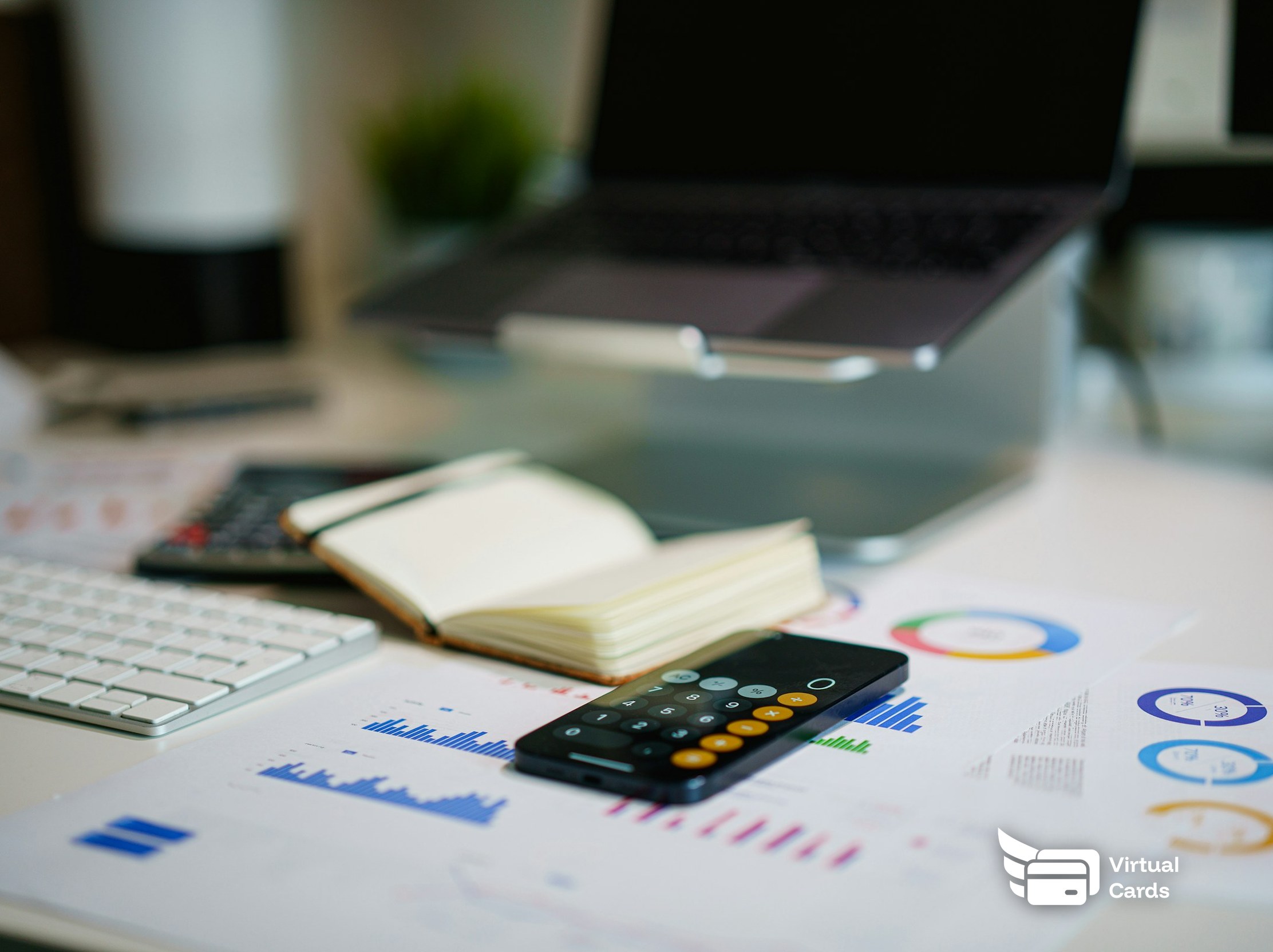 A desk with financial charts, a calculator, and a notebook, representing how to manage law firm expenses with a virtual card.